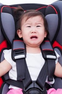 Girl crying at car-seat and fasten seat belt